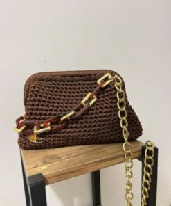 Sac à main artisanal Espresso Chic marron chocolat posé sur un support en bois, mettant en relief le contraste entre la bandoulière dorée et les maillons ambrés.