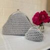 Ensemble duo Harmonie de Patrinova comprenant une pochette grise en crochet fait main et un porte-monnaie coordonné avec fermoirs cliquet argentés. طقم حقيبة يد ومحفظة رمادي براق (Ensemble sac à main et porte-monnaie gris éclatant) حقيبة كروشيه مصنوعة يدويا بقفل كلاسيكي (Sac en crochet fait main avec fermoir classique) صناعة تقليدية تونسية فاخرة للهدايا (Artisanat traditionnel tunisien de luxe pour cadeaux) طقم هرموني بوشيت ومحفظة نقود (Ensemble Harmonie pochette et porte-monnaie)