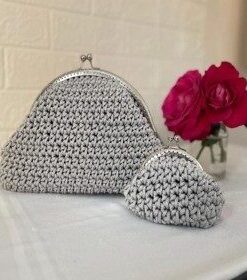 Ensemble duo Harmonie de Patrinova comprenant une pochette grise en crochet fait main et un porte-monnaie coordonné avec fermoirs cliquet argentés. طقم حقيبة يد ومحفظة رمادي براق (Ensemble sac à main et porte-monnaie gris éclatant) حقيبة كروشيه مصنوعة يدويا بقفل كلاسيكي (Sac en crochet fait main avec fermoir classique) صناعة تقليدية تونسية فاخرة للهدايا (Artisanat traditionnel tunisien de luxe pour cadeaux) طقم هرموني بوشيت ومحفظة نقود (Ensemble Harmonie pochette et porte-monnaie)