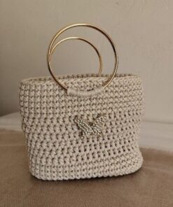 Sac à main artisanal Papillon Doré de Patrinova en crochet couleur sable avec anses circulaires rigides en métal doré et motif papillon scintillant. حقيبة يد كروشيه بلون رملي طبيعي (Sac à main en crochet couleur sable naturelle) حقيبة يد الفراشة الذهبية للمناسبات (Sac à main Papillon Doré pour événements) صناعة تقليدية تونسية فاخرة بمقبض ذهبي (Artisanat traditionnel tunisien de luxe avec poignée dorée) حقيبة سهرة تونسية راقية مصنوعة يدويا (Sac de soirée tunisien raffiné fait main)