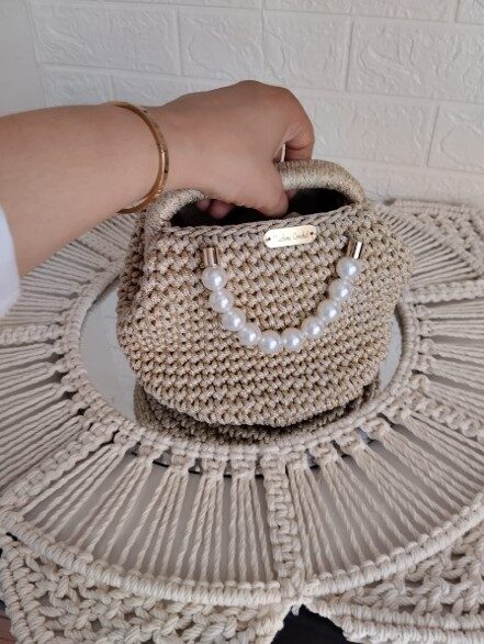 sac-perle-d-or-crochet-dore-anses-perles-patrinova Sac à main artisanal Perle d'Or de Patrinova par Madame Crochet en fil texturé doré brillant avec double anse en perles blanches. حقيبة يد ذهبية للمناسبات والأعراس (Sac à main doré pour événements et mariages) حقيبة كروشيه يدوية الصنع خيط ذهبي (Sac en crochet fait main fil doré) صناعة تقليدية تونسية فاخرة مدام كروشيه (Artisanat traditionnel tunisien de luxe Madame Crochet) حقيبة يد نسائية راقية بالخرز الأبيض (Sac à main pour femme raffiné avec perles blanches)